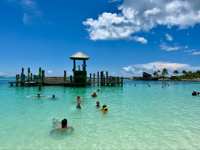 Swimmers swim in beautiful aquamarine water on Disney Cruise Line's private island Castaway Cay in the Bahamas.