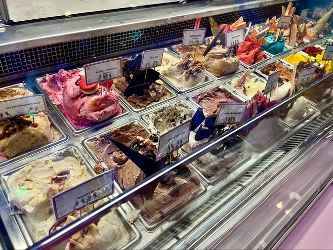 A range of colorful gelato flavors is found in the dessert shop 'Inside Out: Joyful Sweets' aboard Disney Wish cruise ship.