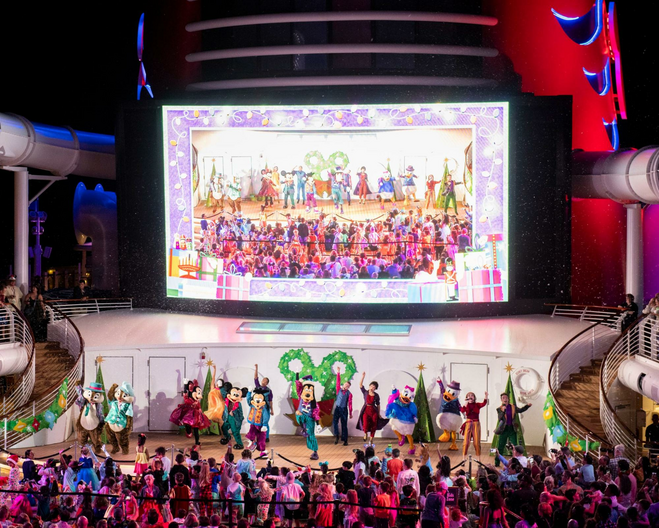 Disney characters (including Goofy, Mickey, Minnie, Daisy, Donald and Chip and Dale) dance during a holiday-themed deck party aboard a Very Merrytime sailing on a Disney cruise ship.