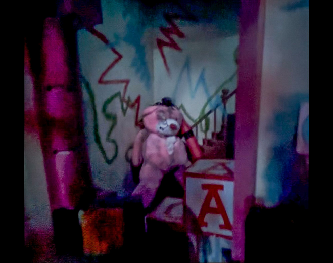 broken toy behind large letter blocks