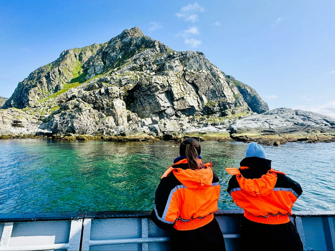 Two women wearing warm clothing while birdwatching.