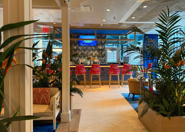 Tropical vibes at Margaritaville Resort lobby and License to Chill bar. View of bar area with red barstools.