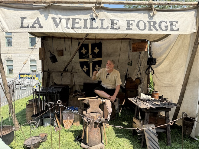 A craftsman explaining the Forge, a skill essential in the 16th and 17th centuries during Fêtes de la Nouvelle-France, perfect for vacationing couples.