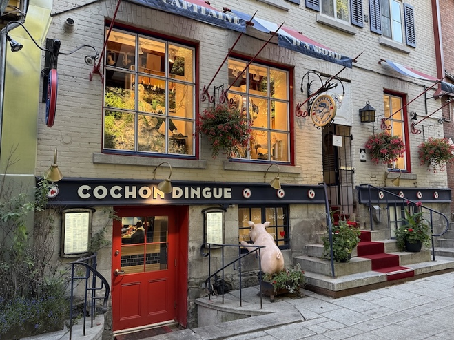 Shops with hanging flowers and window displays on Rue du Petit-Champlain, a charming stroll for couples enjoying a romantic Québec City escape.
