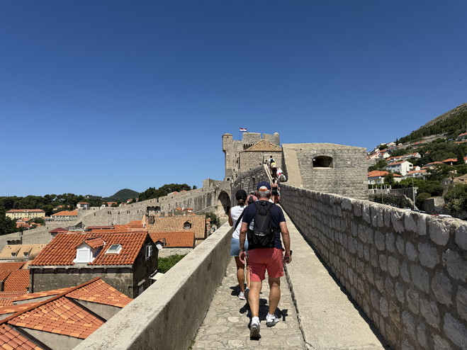 Tour group walking along the top of Dubrovnik's city wall on the Game Of Thrones Tour.