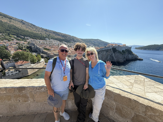 Family posing atop the famous Fort Lovrijenac, known as the Red Keep in Game of Thrones, with Dubrovnik's city and harbor in background.