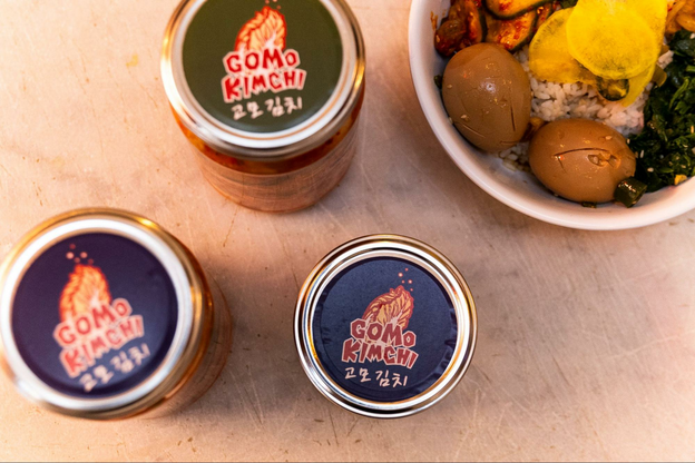 jars of kimchi, blue lids, labeled "Gomo Kimchi"