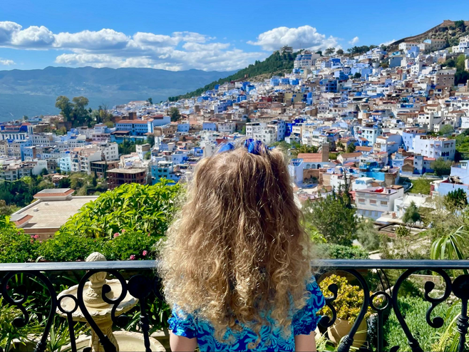 A young girl overlooks the blue-colored town of Chefchaouen in Morocco.