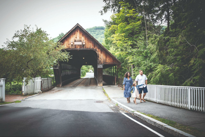the historic middle covered bridge in woodstock, vermont with a family. 
