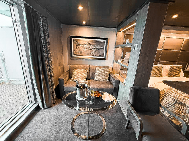 View of sitting area in cruise ship stateroom with champagne and fruit plate on the coffee table