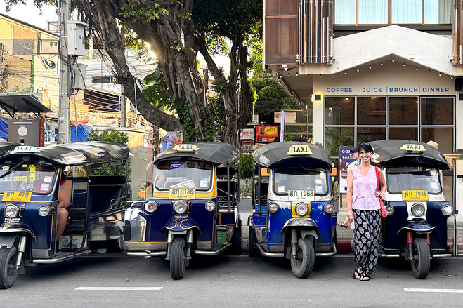 Author standing in front of colorful Tuk Tuks