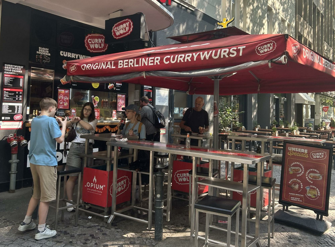 A stand selling Berlin's quintessential street food, currywurst, in the heart of the city's lively entertainment district. 