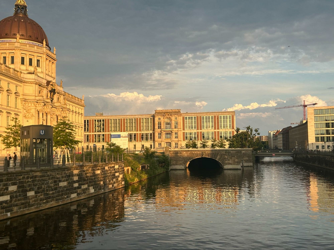 Berlin's buildings reflected in the water at sunset. 