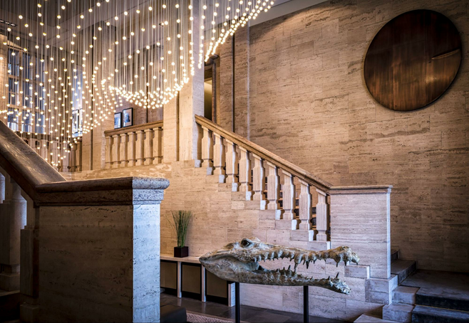 The elegant lobby of the So/Berlin Das Stue with its marble staircase, cascading light feature and alligator sculpture. 