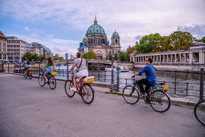Bikers on a guided tour of Berlin's highlights riding across a bridge to Museum Island. 