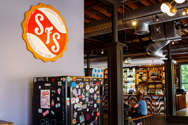 Round wooden Southern Feed Store sign hanging on a brewery wall in Atlanta