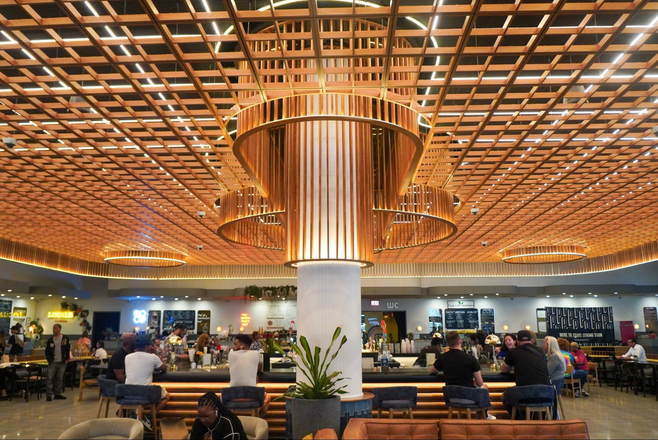 People sitting at Politan Row at Colony Square's horseshoe-shaped bar in Atlanta