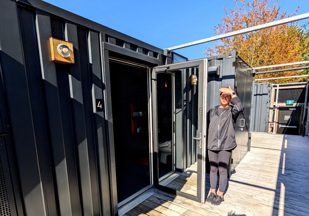 Attendant holds open the door to a wellness pod at Circle Wellness in Vancouver.