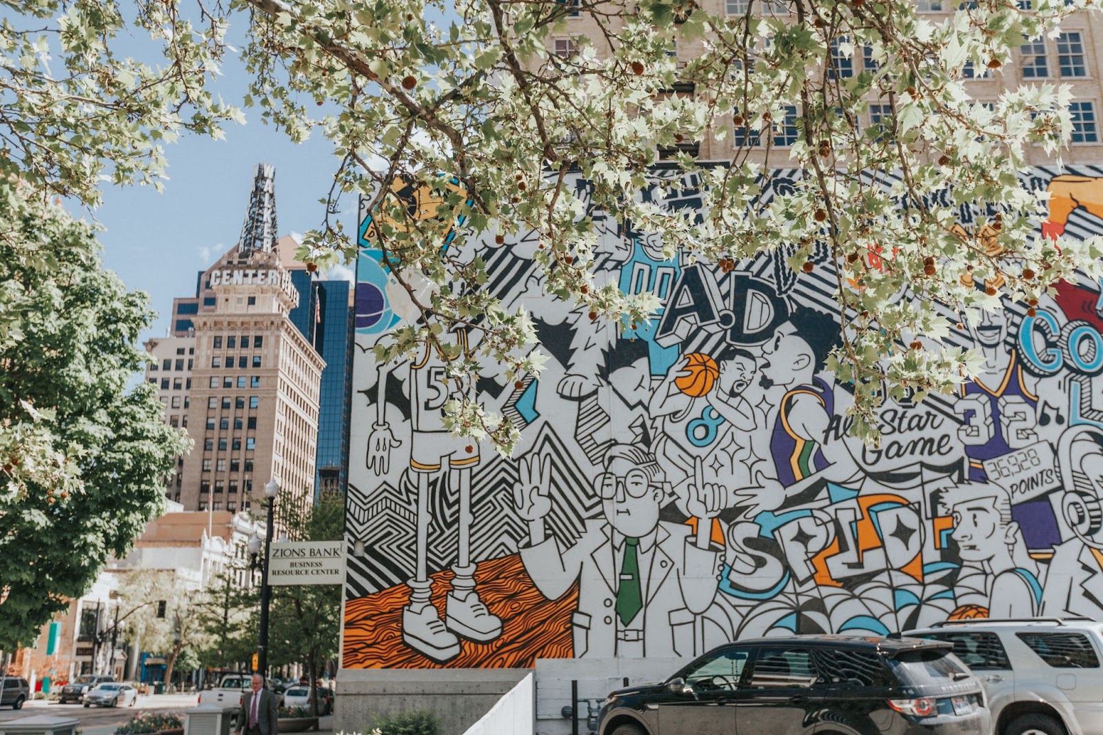 Colorful mural in Salt Lake City with a flowering tree beside it