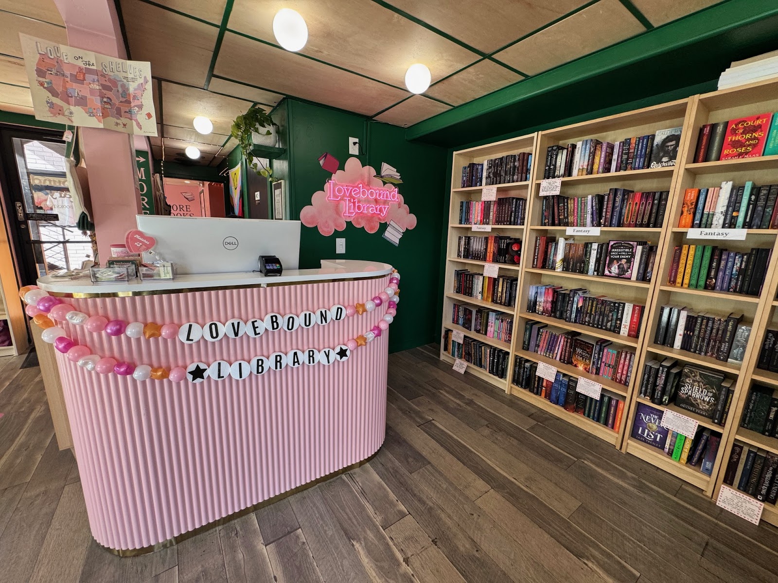 Salt Lake City romance bookstore interior with book cases and a pink and white striped check-out desk.