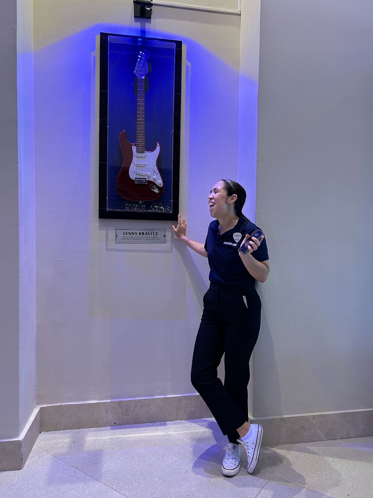 A woman shows off the guitar of Lenny Kravitz on display at the Hard Rock Hotel in Punta Cana