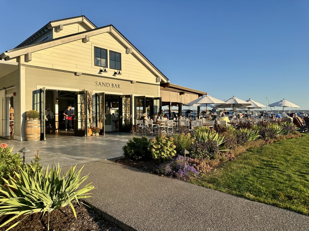 Exterior of the Sand Bar restaurant at the Lake House on Canandaigua with lush landscaping and outdoor umbrellas.