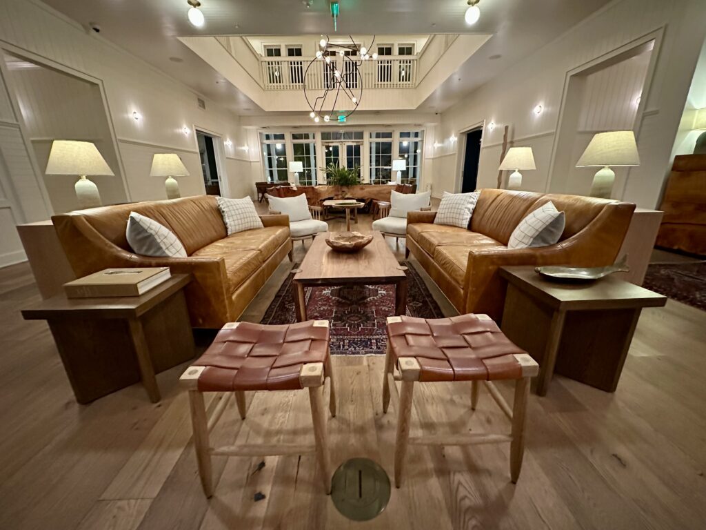 Lake House on Canandaigua lobby featuring caramel leather sofas, woven brown leather stools and a dramatic sculpted wire chandelier.