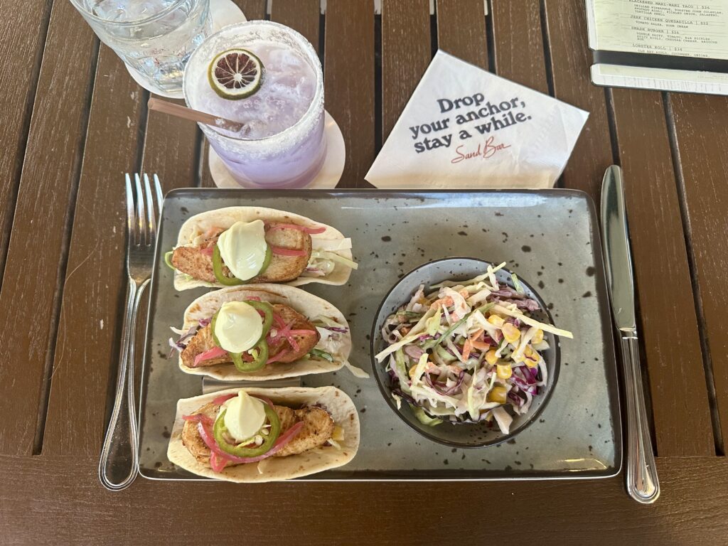 Three mahi mahi tacos, bowl of colorful slaw, and a lavender cocktail at The Sand Bar at the Lake House on Canandaigua.