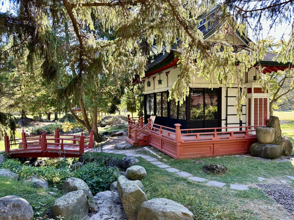 Japanese teahouse and red bridge in a formal garden at the Sonnenberg Mansion in New York's Finger Lakes.
