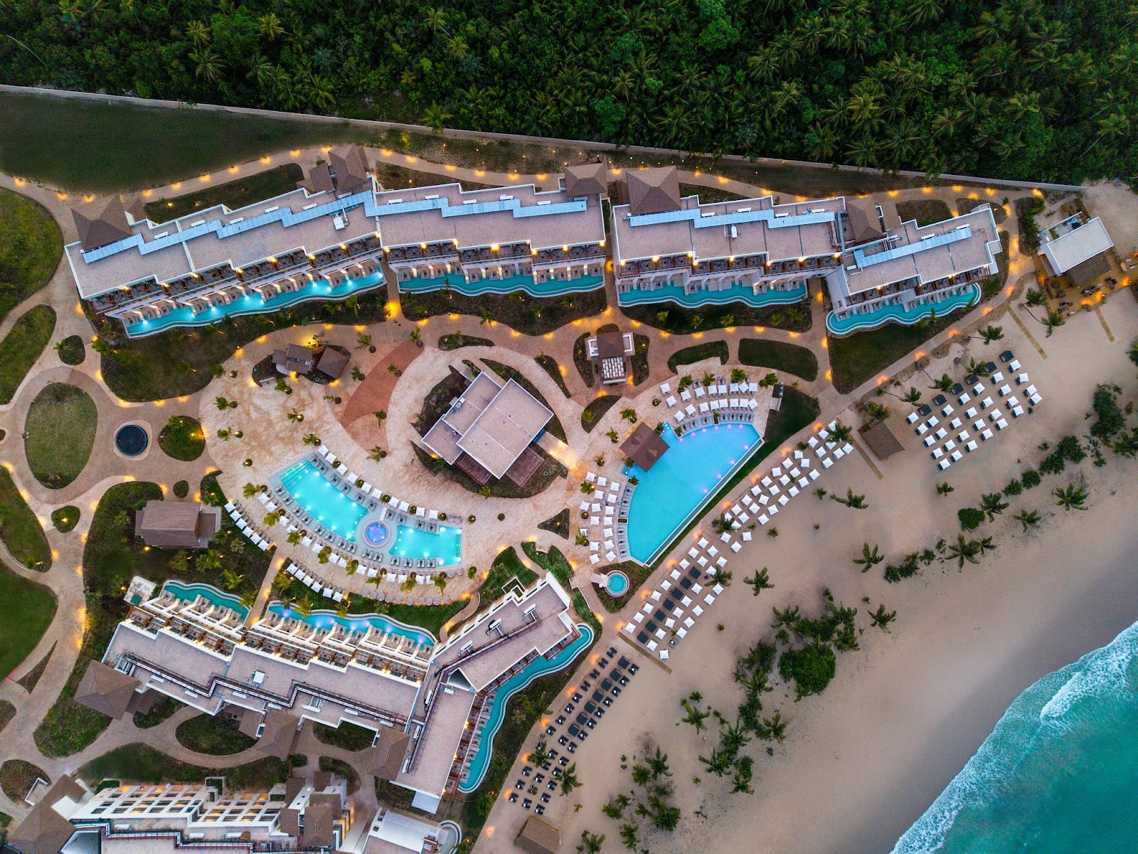 Secrets Playa Esmeralda adults-only all-inclusive resort from above showing tan buildings, turquoise pools and beach