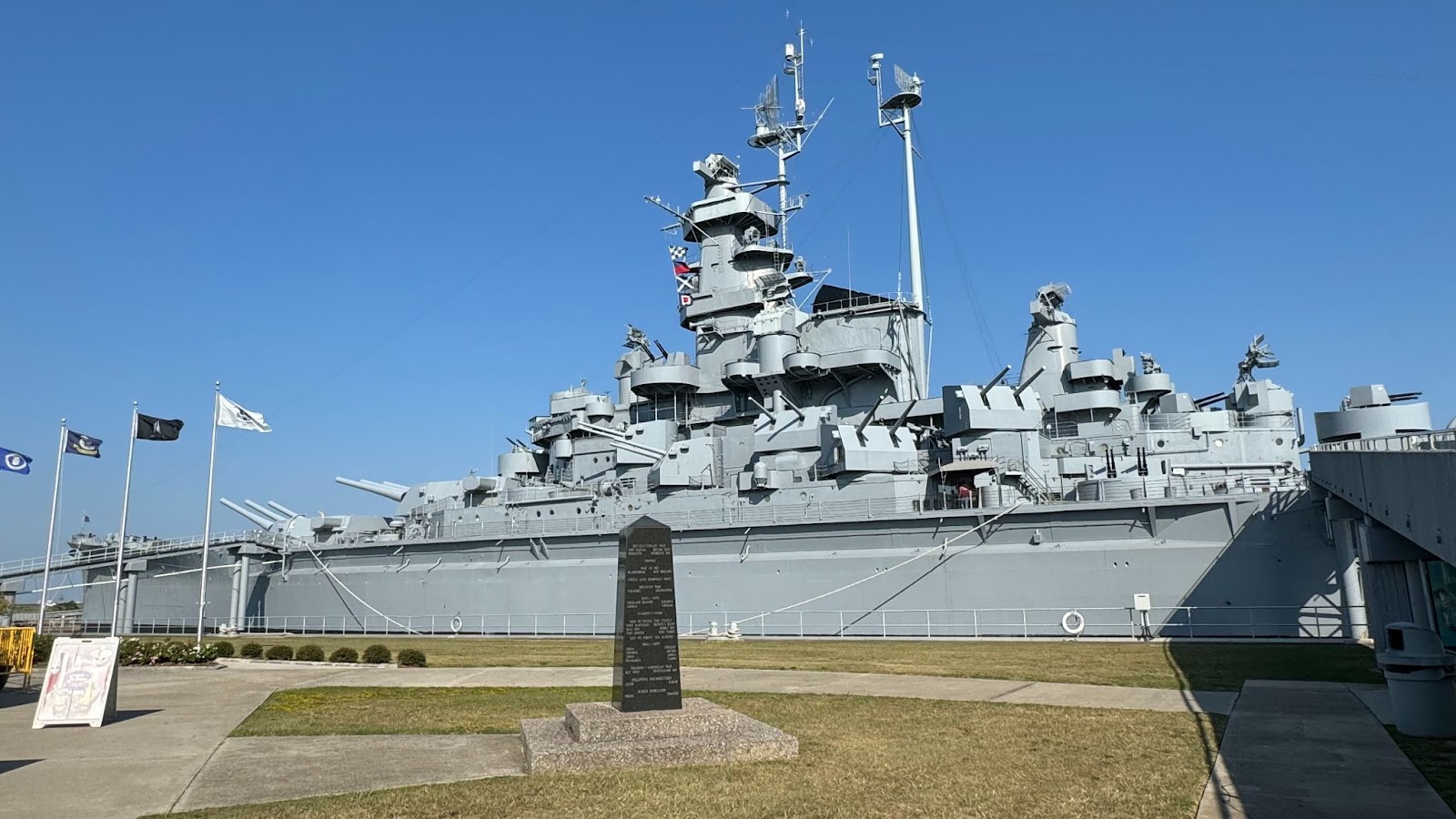 Large grey USS battleship on a plot of grass next to a stone a short drive away from Hyatt Studios Mobile Tillman's Corner