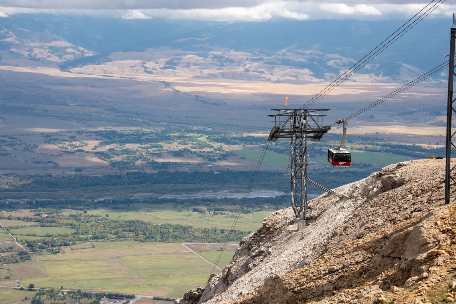 Watching a mountain tram lower into the valley below in the Teton mountains