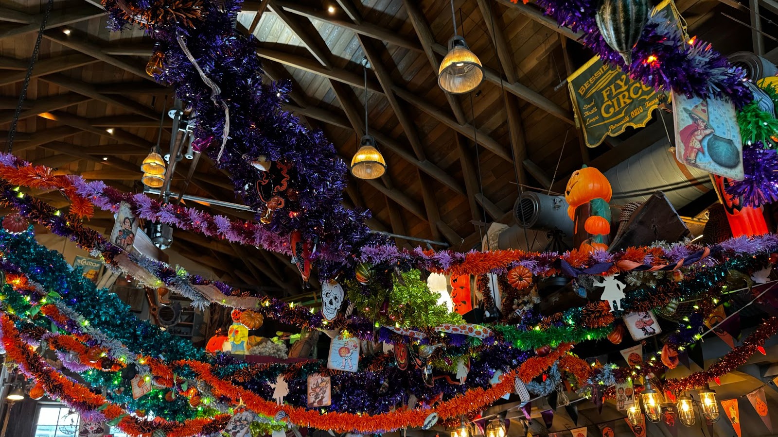 Orange and purple garlands and pumpkin and skeleton decorations inside of Halloween bar in Orlando, Jock Lindsey's Halloween Hangar Bar