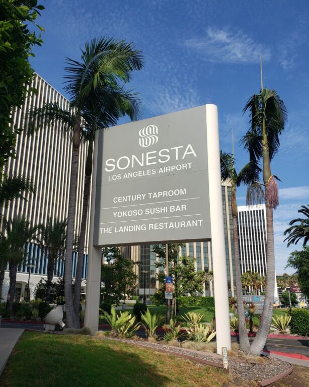 Gray exterior sign with white lettering that says,