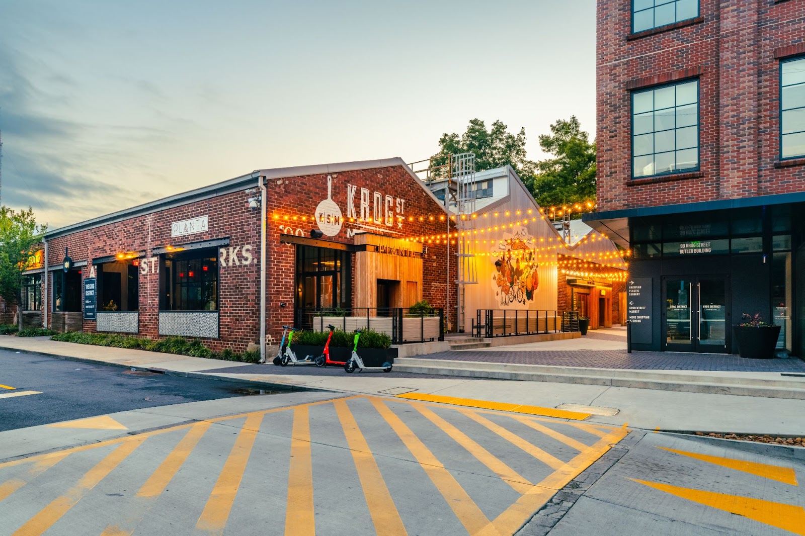 Brick building that houses Krog Street Market food hall in Atlanta decorated with string lights