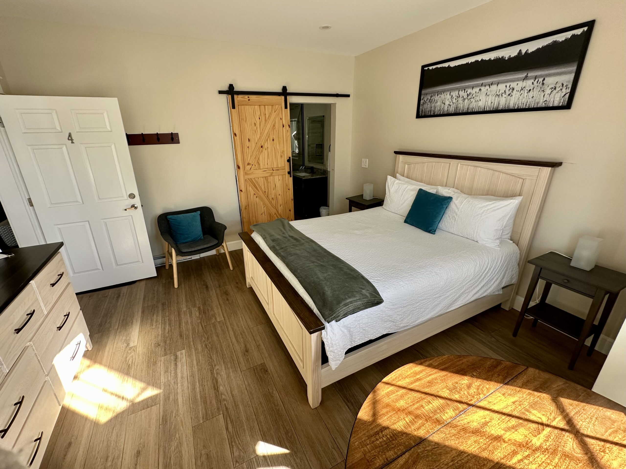 Queen bedroom at the Riverside Inn in New Glasgow, Nova Scotia with a barn door entrance to the bathroom.
