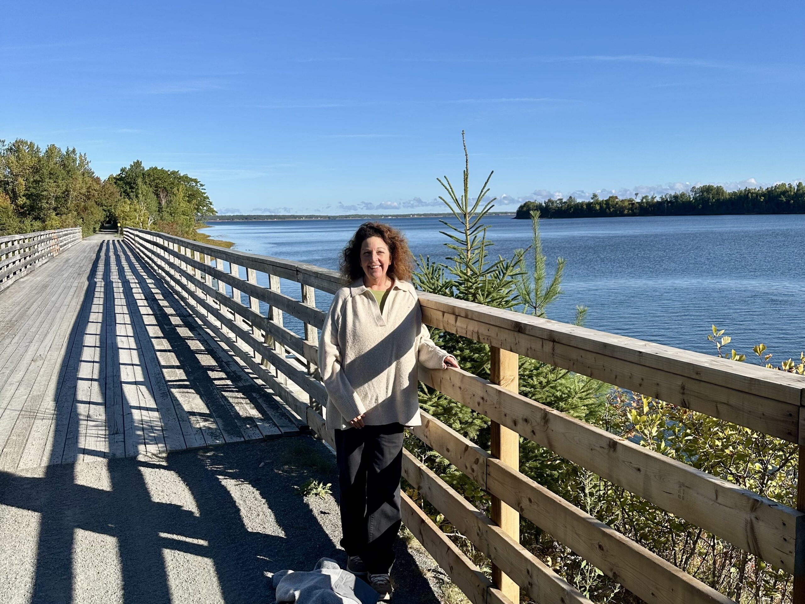 Woman on the Trans Canada Trail in Nova Scotia with a lake in the background.