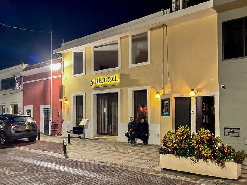 Restaurant facade with two small black doors located to the right, giving access to a secret bar.