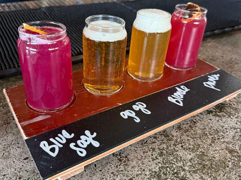 Four glasses of beer arranged on a wooden plank at a brewery in Reno.