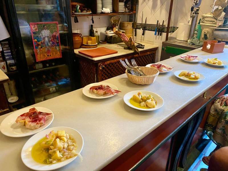 six small plates plates of tapas along the bar