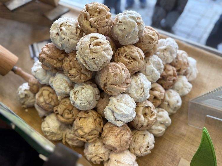 Stacked Schneeball pastries in a shop window in Rothenburg ob der Tauber, dusted with powdered sugar