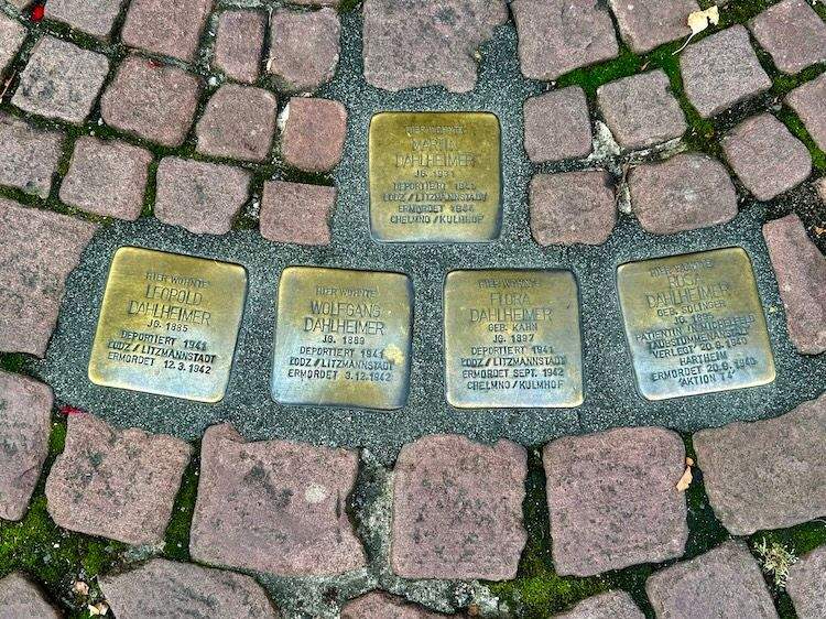Brass Stolpersteine embedded in a cobblestone street in Miltenberg, honoring Jewish residents lost during the Holocaust.