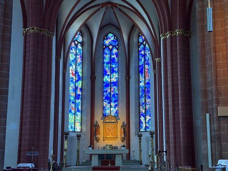 Blue stained-glass windows by Marc Chagall in St. Stephen’s Church, Mainz, glowing above the altar as a symbol of post-WWII reconciliation.