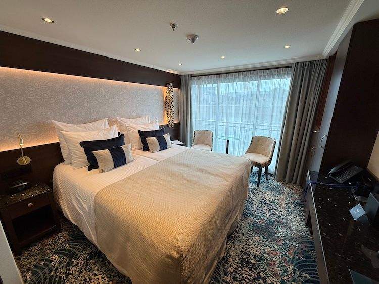 Interior of my MS George Eliot cabin with a French balcony and calming décor.