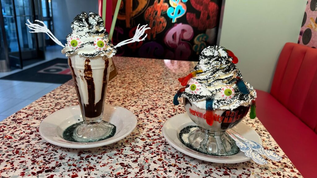Two ice cream sundaes in a glass cup with whipped cream and gummy worms inspired by the Beetlejuice play.