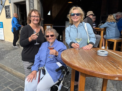 Cruise guests—a mother and her two daughters—enjoying wine together on Würzburg’s Old Main Bridge.