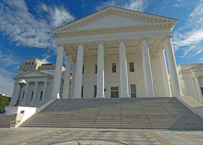 A classic white columned building with large steps leading to it.