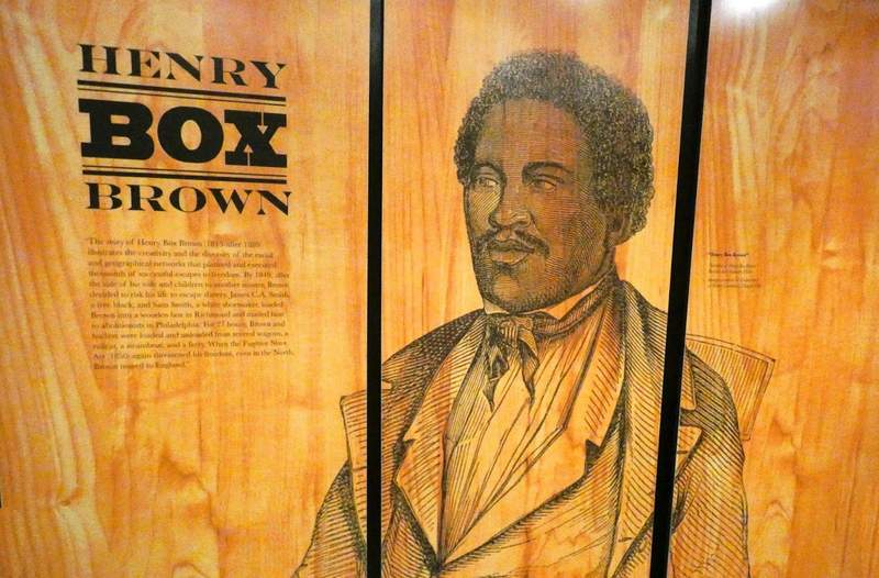 Black man's image with name Henry Box Brown on wall.