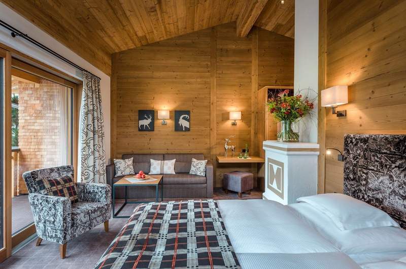 A spacious room at the Hotel Auenhof Hotel with modern alpine design, light wood and rich décor accents. 