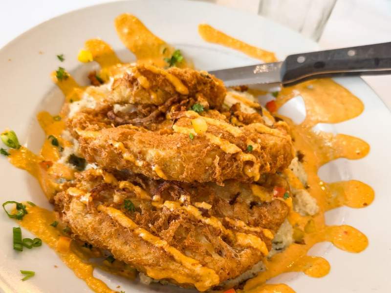 Plated cauliflower steak at Dajio on Ocracoke Island, garnished with seasonal vegetables and sauce.